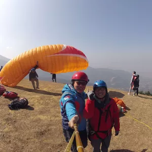 paragliding pilot and a girl taking photo at Chapakharka, Kathmandu Paragliding take-off